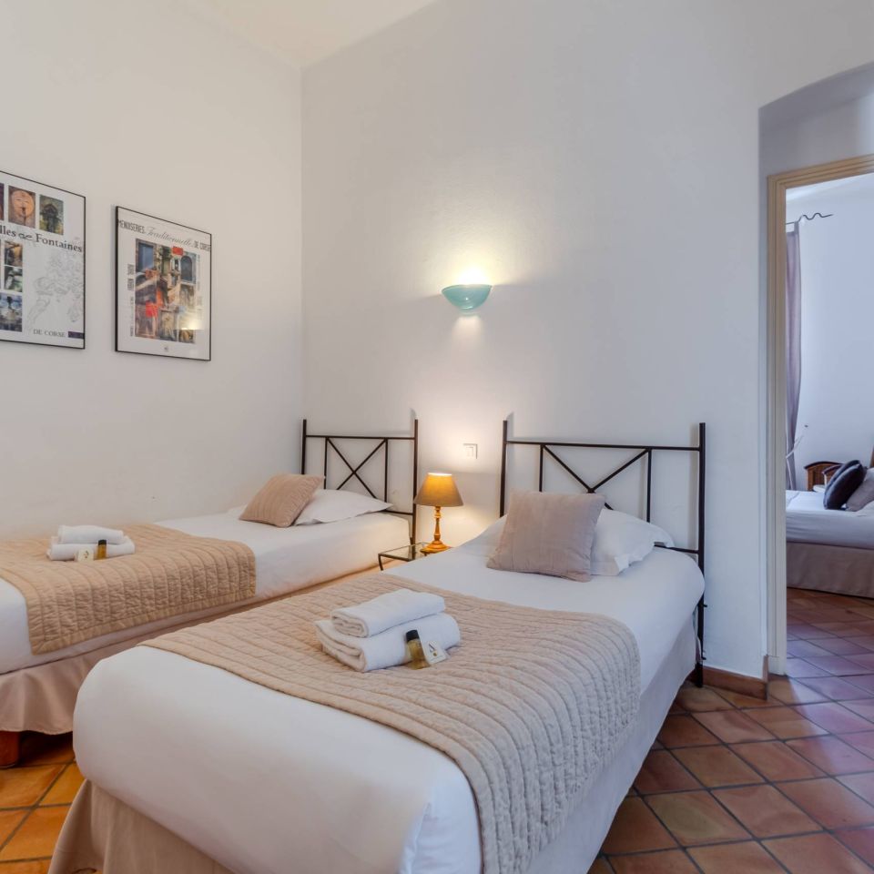 Bright bedroom with two single beds, decorative wall art, and a cosy atmosphere.