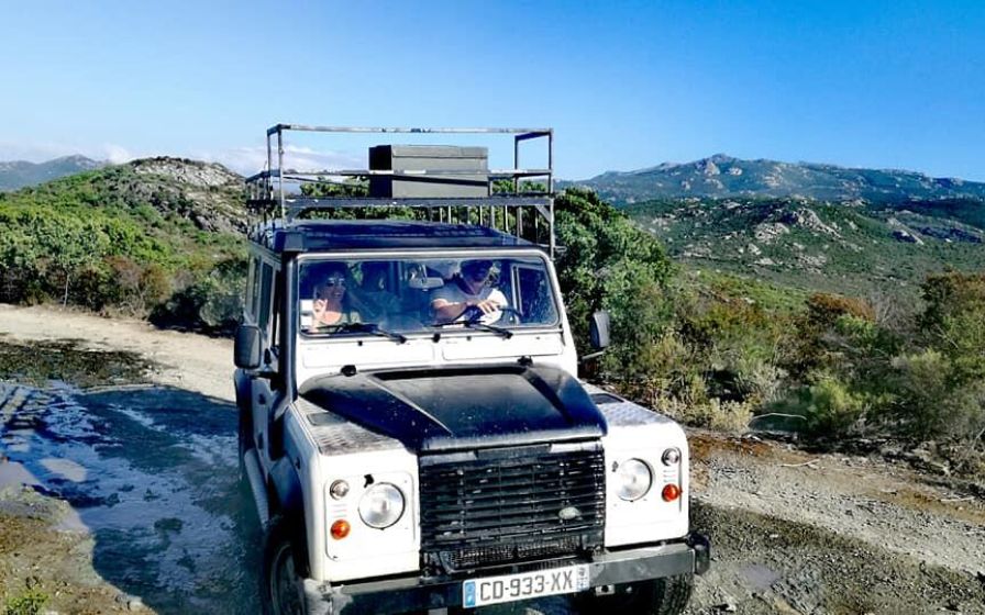 Veicolo 4x4 su una pista di Balagne in Corsica, con una vista mozzafiato sulle montagne.