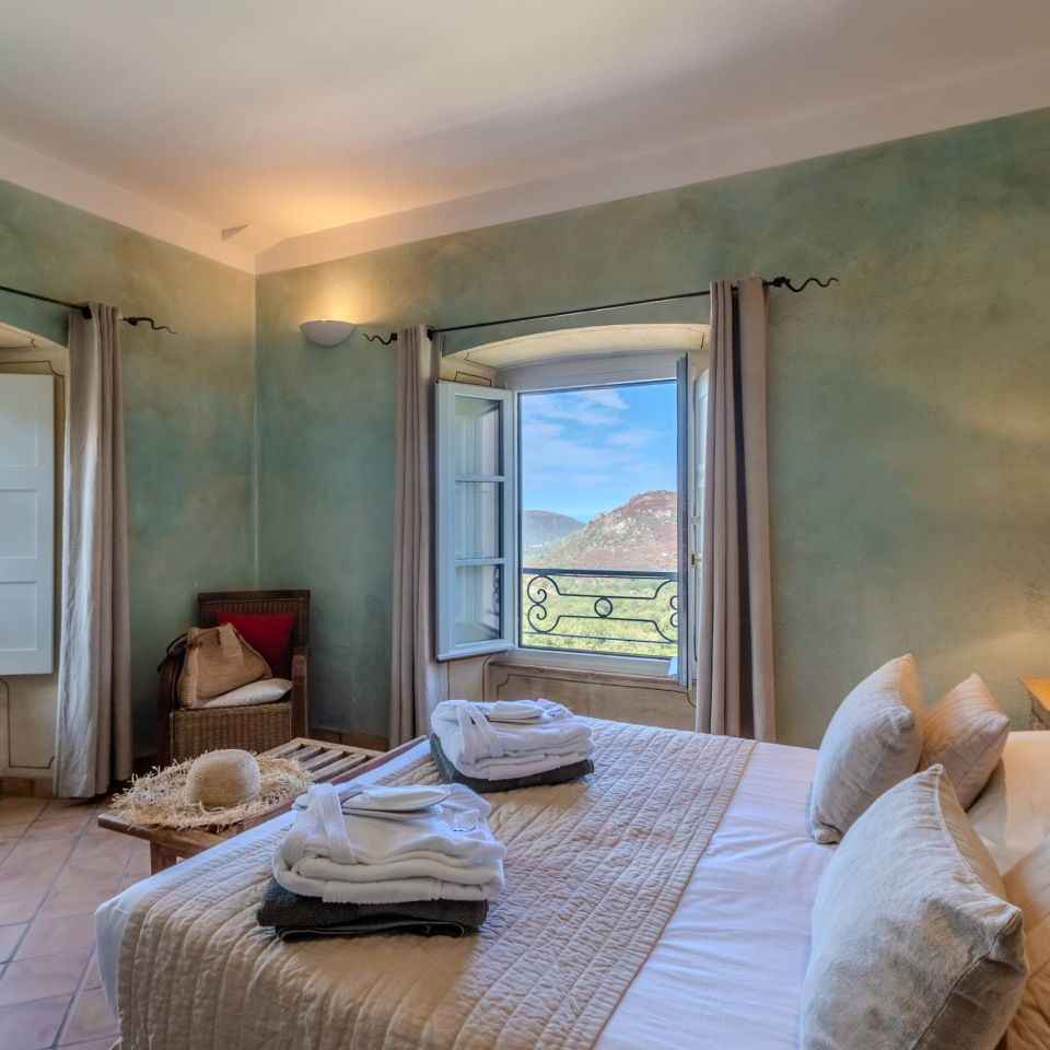 Charming room with a view, featuring soft bedding, natural decor, and a warm atmosphere.