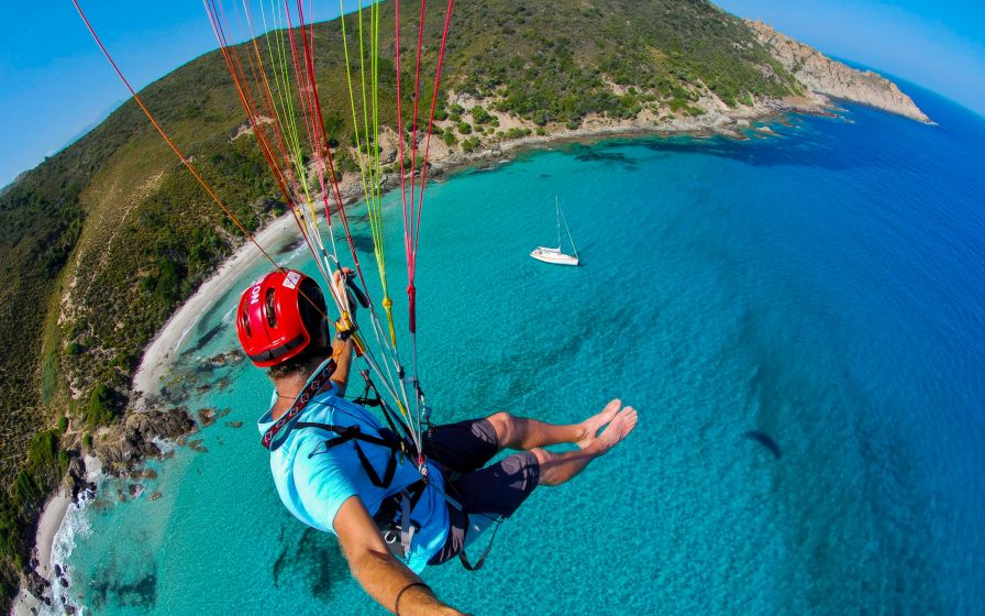 Parapendista che sorvola le spiagge di Balagne in Corsica