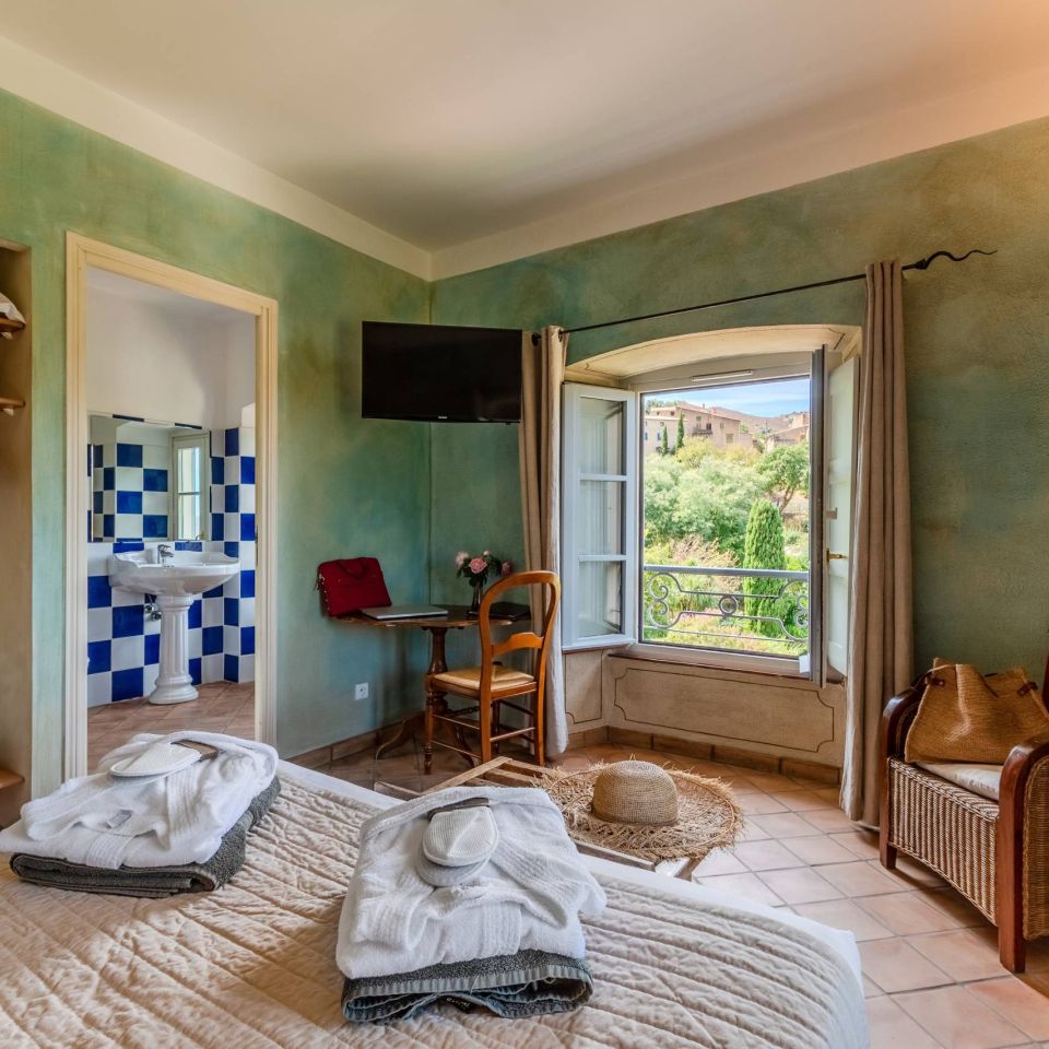 Charming room with a bed, a view, and elegant decor, featuring a bathroom and seating area.